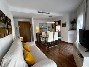 un salon avec un canapé blanc et une table dans l'établissement Lo balconet del Delta. Àtic-dúplex vacacional., à Amposta