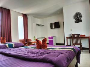 a dog is laying on a purple bed at Davyta House in Siem Reap