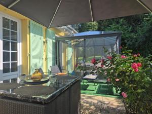 un patio al aire libre con mesa y sombrilla en Gîte les jardinette 3 personnes, en Futeau 4 fotos más