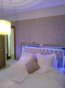 a bedroom with a large bed with white sheets and pillows at Maison 10 pièces Spa jacuzzi Paris Airport CDG jardin arboré clos in Tremblay En France