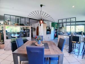 a kitchen and dining room with a wooden table and chairs at Gers habitation in Montégut