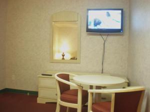 a room with a table and a tv on the wall at Red Carpet Inn & Suites Hammonton - Atlantic City in Hammonton
