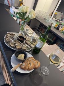 a table with two plates of oysters and a bottle of wine at Au Complex By Suprême in Laboutarié
