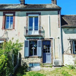 an old house with a blue door and a balcony at Maison cosy - Centre - Perche in Tourouvre