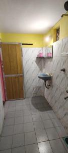 a bathroom with a toilet and a wooden door at Laxmi in Arambol