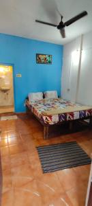 a bed in a room with a blue wall at Laxmi in Arambol