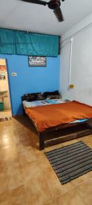 a bed in a room with a blue wall at Laxmi in Arambol