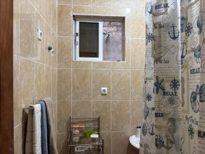 a bathroom with a shower and a toilet and a window at Techas Near Beach 3 Bed Apt Tarrafal in Tarrafal