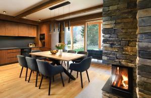 Una cocina y un comedor con chimenea. en Chalet Oasis - Luxury 5-Bedroom Chalet with Panoramic Views, en Huty