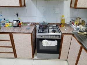 a kitchen with a stove with a pot on it at 1 Separate Bedroom and Attached Bathroom in a shared apartment in Muscat