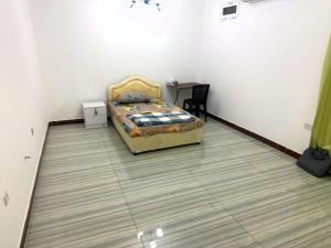 a bedroom with a bed and a table in a room at 1 Separate Bedroom and Attached Bathroom in a shared apartment in Muscat