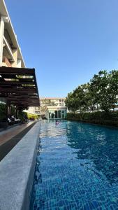 einem Pool mit blauem Wasser vor einem Gebäude in der Unterkunft Peaceful Stay at MT Khlong Luang Self-Check-in เช็คอินด้วยตนเอง in Khlong Luang