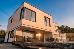 a house with a bunch of chairs in front of it at Villa Felicia in Malinska