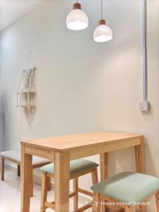 a dining room table with two lights and two chairs at Muji Ipoh Falim Free Parking & Free Netflix in Ipoh