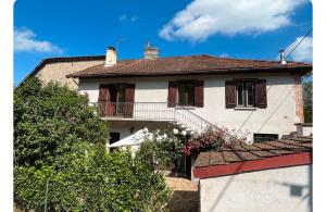 a white house with a balcony on top of it at La Maison du Foirail in Aurillac