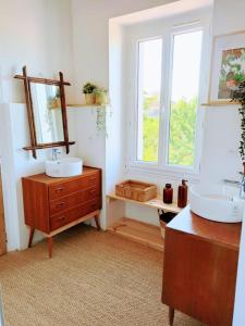 a bathroom with two sinks and a mirror on a dresser at Maison de vacances - côte de Jade - coup de coeur in La Plaine-sur-Mer +35 photos