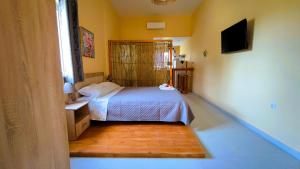 a bedroom with a bed and a television in it at Joy's Houses in Marmari