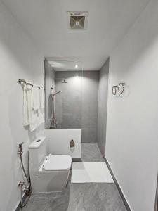 a white bathroom with a toilet and a shower at Muraka Dhigurah in Dhigurah +22 photos