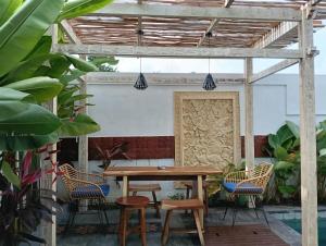 a patio with a wooden table and chairs at Otila Bali Villa in Uluwatu