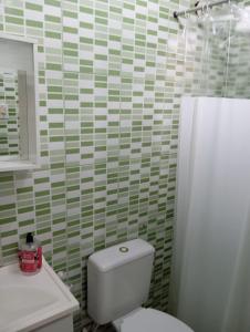 a bathroom with a white toilet and a sink at casa Amarela in Tamoios +8 photos