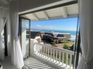a balcony with a view of the ocean at Frank Road At The beach in St Francis Bay