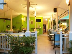 a restaurant with green walls and tables and chairs at Sawasdee Sukhumvit Inn in Bangkok