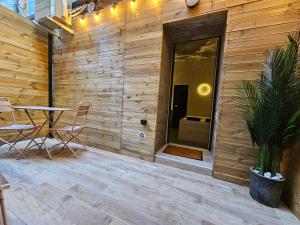 a wooden wall with a table and chairs on a patio at Suite Intemporelle in Montagnac