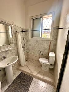 a bathroom with a toilet and a sink and a window at Nomads Hostel Tunisia in Tunis +204 photos