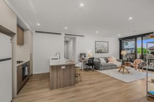 a kitchen and living room with a couch and a table at "The Mowbray"-Luxury,rooftop pool,gym,free parking in Brisbane
