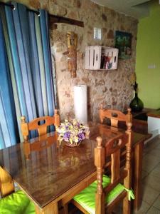 a dining room table with chairs and flowers on it at La Fuente in Umbrías +3 photos