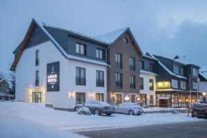 a hotel with two cars parked in the snow at LODGE HOTEL Winterberg in Winterberg