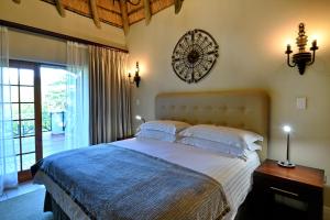 a bedroom with a bed and a clock on the wall at Champagne Castle Hotel in Champagne Valley +64 photos