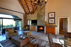 a living room with a fireplace and a table at Champagne Castle Hotel in Champagne Valley