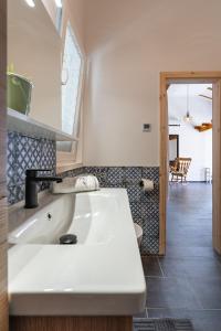 a bathroom with a white sink and a room at Summer cottage 1 in Novalja