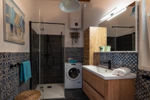 a bathroom with a sink and a washing machine at Summer cottage 1 in Novalja +17 photos