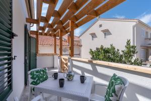 a patio with a table and chairs on a balcony at Summer cottage 1 in Novalja
