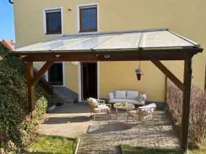 a pavilion with a couch and chairs on a patio at Ferienwohnung Michaela in Neualbenreuth