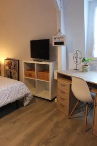 a bedroom with a bed and a desk with a television at Studio 211 au cœur du campus de Belle Beille in Angers