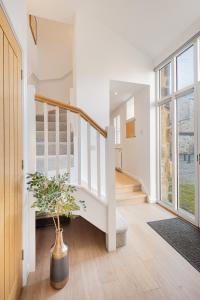 a white staircase in a home with a potted plant at The Old Weigh House in Kirkby Lonsdale