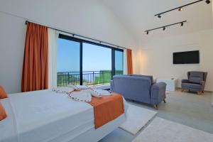 a bedroom with a bed and a chair and a large window at Villa Montana 1 in Fethiye