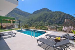 a swimming pool with two chairs and a roller coaster at Villa Montana 1 in Fethiye
