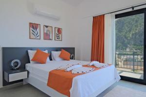 a bedroom with a white bed with an orange blanket at Villa Montana 1 in Fethiye +44 photos