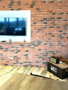 a brick wall with a window and a box on a table at Le Loft d 'Éveux - 2 places de parking in Éveux