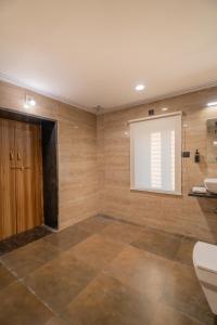 ein Badezimmer mit Toilette und Waschbecken und einem Fenster in der Unterkunft Amoraya Udaipur in Udaipur