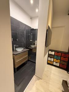 a bathroom with a sink and a toilet and a television at Le Loft d 'Éveux - 2 places de parking in Éveux +8 photos