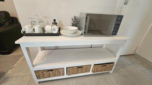 a microwave on top of a white table at Honeywood Stays - "Romantic escape" Sunroom Near Airport, Fast Wi-Fi & Secure Parking in Gqeberha