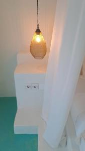 a light hanging from a ceiling in a room at Guru Canggu in Canggu