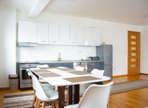 a kitchen with a table and chairs and a refrigerator at Sarajevo Gate in Sarajevo