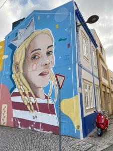un mural de una mujer al lado de un edificio en JScAsa Rainha Centro, en Caldas da Rainha