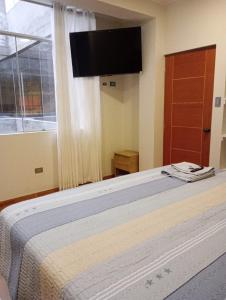 a bedroom with a bed with a flat screen tv at Exclusivo Depa Cerca Precio Uno para 10 in La Merced